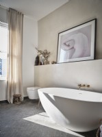 Salle de bain moderne avec baignoire blanche et œuvres d'art