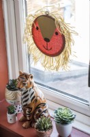 Ornements de lion et de tigre sur le rebord de la fenêtre avec de petites plantes succulentes