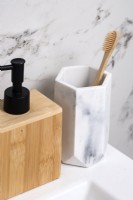 Détail du porte-brosse à dents en marbre et du distributeur de savon en bois