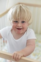 Enfant souriant bébé garçon dans un lit bébé dans la chambre de la crèche