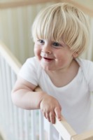 Enfant souriant bébé garçon dans un lit bébé dans la chambre de la crèche