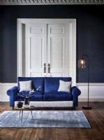 Canapé bleu moderne dans une chambre bleue avec tapis et lampadaire