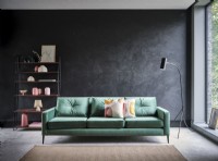 Canapé vert contre un mur tacheté de gris