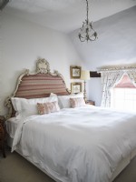 Chambre rose et blanche avec tête de lit ornée