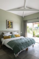 Chambre à coucher moderne avec portes-fenêtres menant à la terrasse en été