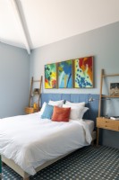 Œuvres d'art colorées au-dessus du lit dans une chambre moderne