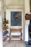 Oeuvre au-dessus d'un fauteuil en bois dans un salon de campagne