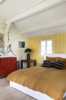 Chambre de campagne moderne avec des murs en bois peints en jaune