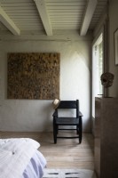 Chaise noire et œuvres d'art dans une chambre de campagne moderne
