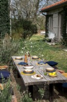 Table de salle à manger extérieure rustique dressée pour le déjeuner à l'extérieur de la maison de campagne