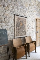 Sièges de cinéma en bois vintage contre un mur en pierres apparentes