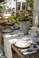Arrangement de fleurs sur une table à manger extérieure dressée pour le déjeuner
