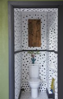 Toilettes au rez-de-chaussée avec papier peint à motifs et art mural de cactus.