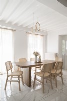 Salle à manger blanche avec des meubles en bois clair