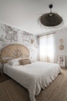 Chambre à coucher de pays avec le mur nu de plâtre et le tapis de sisal