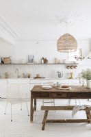 Cuisine-salle à manger de campagne blanche avec table et banc en bois