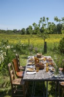Table à manger extérieure en bois rustique dans un jardin de campagne