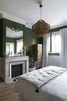 Cheminée dans une chambre peinte en vert et blanc avec des détails d'époque