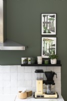 Œuvres d'art modernes sur un mur de cuisine peint en vert - détail