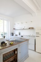 Îlot en bois vieilli dans une cuisine moderne avec réfrigérateur-congélateur Smeg