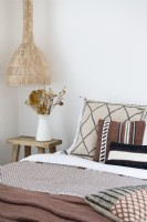 Coussins noirs, blancs et marron sur le lit dans une chambre de campagne moderne
