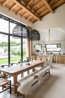 Cuisine-salle à manger moderne avec des peaux de mouton drapées sur des bancs en bois