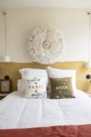 Chambre à coucher moderne avec coussins brodés et art mural en tissu