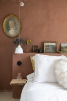Mur et tête de lit peints en marron avec portrait vintage dans la chambre