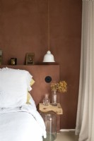 Chambre moderne peinte en marron avec literie blanche