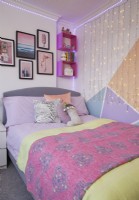 Chambre à coucher avec blocage des couleurs, guirlandes lumineuses et mur de galerie.