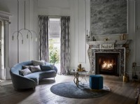 Grand salon avec cheminée en marbre, canapé et rideaux
