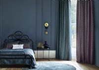 Chambre bleu foncé avec grande fenêtre et rideaux