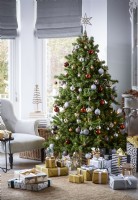 Arbre de Noël dans le salon avec des cadeaux emballés en or et en argent