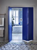 Salle de bain attenante aux volets bleus dans la porte de séparation