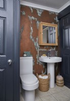 Salle de bain avec mur effet cuivre et portes peintes bleu marine.