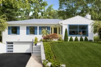 Maison familiale en briques blanches d'un étage moderne du milieu du siècle avec volets bleus et pelouse verte