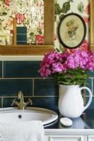 Papier peint à motifs roses dans la salle de bains de campagne
