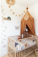 Chambre d'enfant avec lit en bois et tente à baldaquin et pochoirs muraux