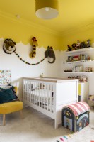 Chambre d'enfant avec lit bébé et plafond festonné jaune