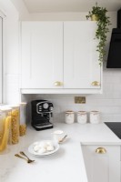 Détail d'un coin dans une cuisine moderne blanche de style avec plan de travail et placard