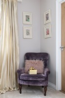 Chaise en velours violet dans le coin d'une chambre
