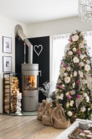 Poêle à bois à cylindre gris à côté d'un arbre de Noël décoré
