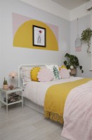 Chambre à coucher avec des formes de blocs de couleur peintes sur le mur.