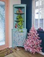 Couloir décoré pour Noël avec un arbre rose couvert de boules. L'armoire a été recyclée.