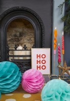 Détail de la cheminée de Noël avec bougies et décorations.