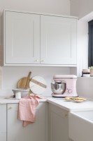 Détail du coin d'une cuisine blanche avec mixeur rose pâle