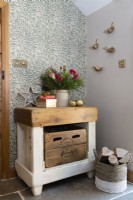Table épaisse de style bloc de bouchers dans un couloir contre un papier peint à motifs de feuilles botaniques
