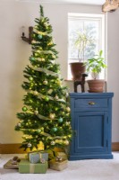 Arbre de Noël à côté d'une armoire peinte en bleu shabby chic recyclé