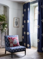 Rideaux bleus et chaise à motifs bleus dans le salon