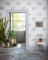 Table avec plantes d'intérieur dans la chambre avec papier peint éléphant